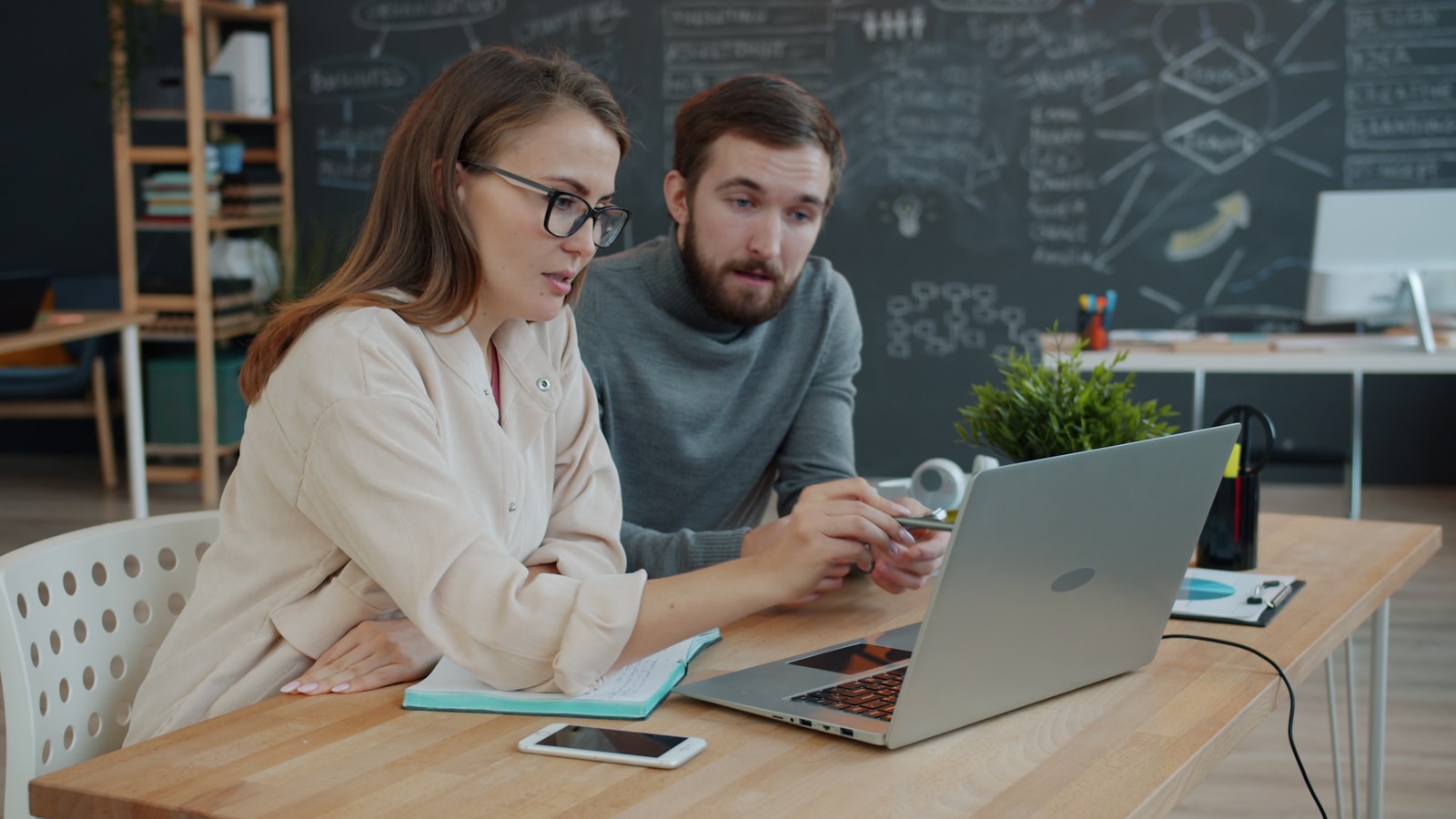 Two colleagues reviewing financials together at a laptop