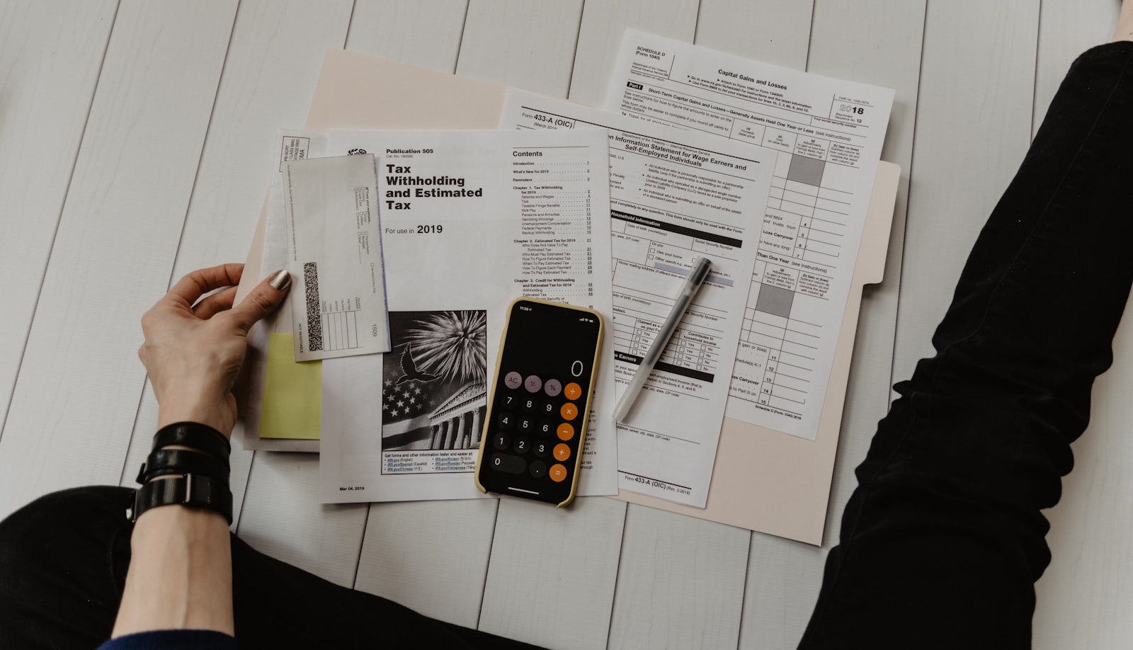 IRS tax forms, envelope, and calculator laid out on a desk